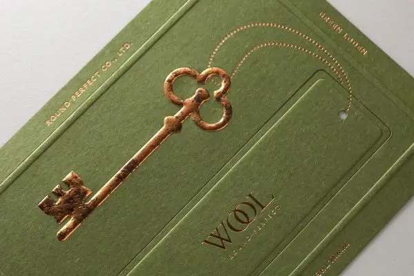 Olive-green textured card with gold-foil skeleton key and 'WOOL' logo