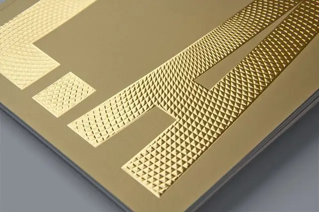 Close-up of gold foil embossed lettering with pyramidal texture