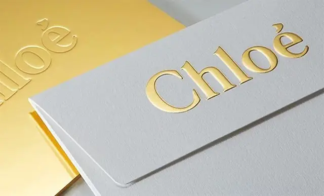 Gold-foiled "Chloè" embossed envelope — luxury stationery close-up
