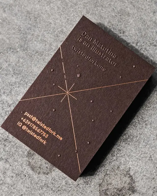 Dark brown business card with copper foil starburst and blind deboss