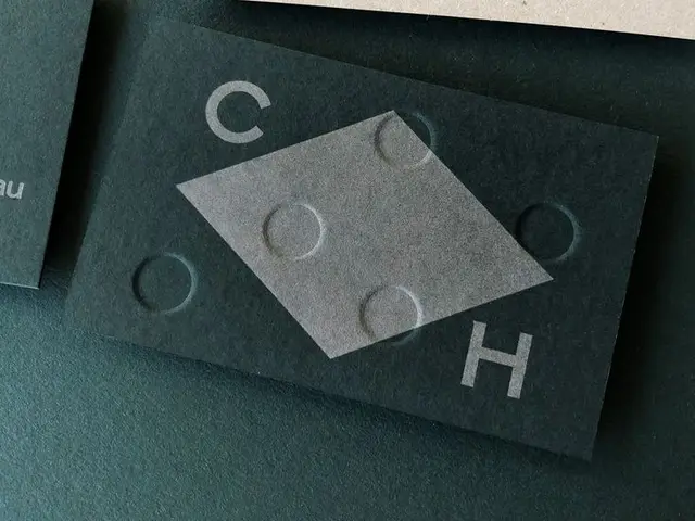 Minimal teal business card with blind-embossed circles and gray rhombus