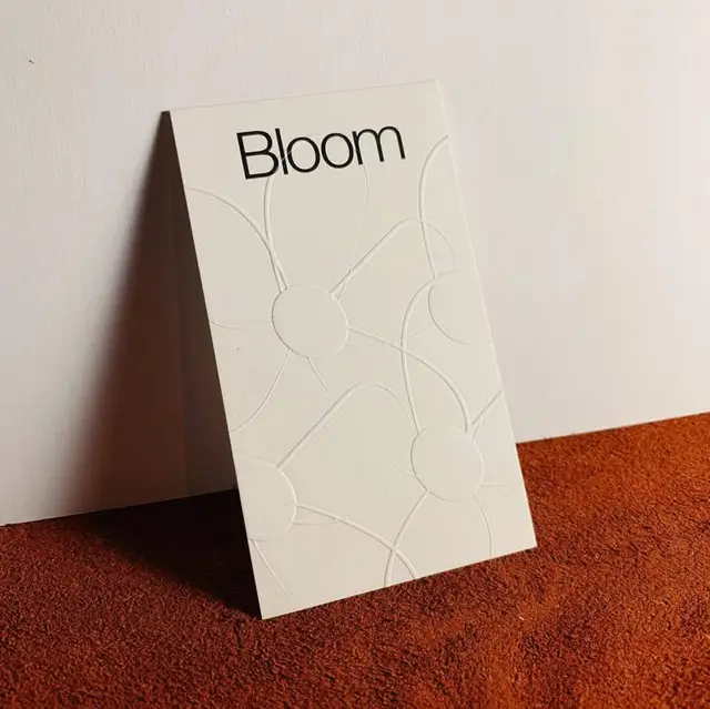 Minimal embossed stationery card with 'Bloom' headline