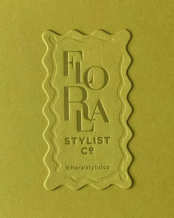 Embossed 'FLORA' logo on olive green letterpress card