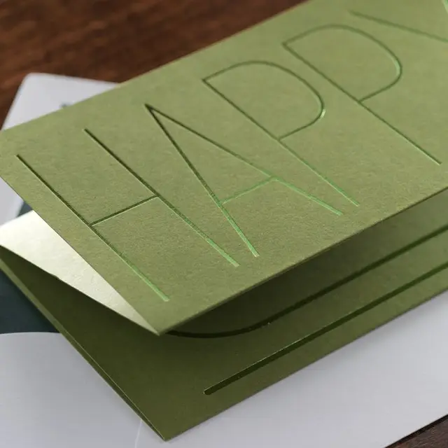 Olive-green folded greeting card with die-cut typographic front