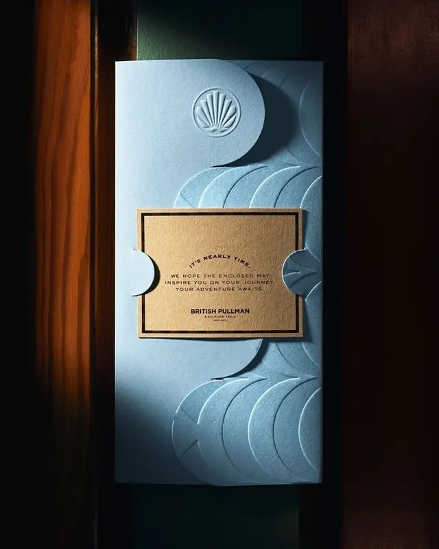 British Pullman embossed invitation — pale blue die-cut sleeve with kraft insert