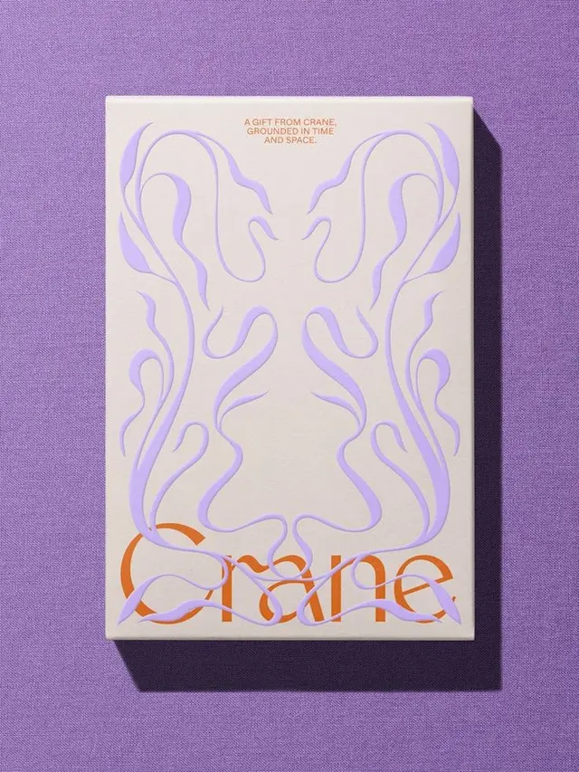 Crane cream gift box with lavender embossed flourishes on purple fabric