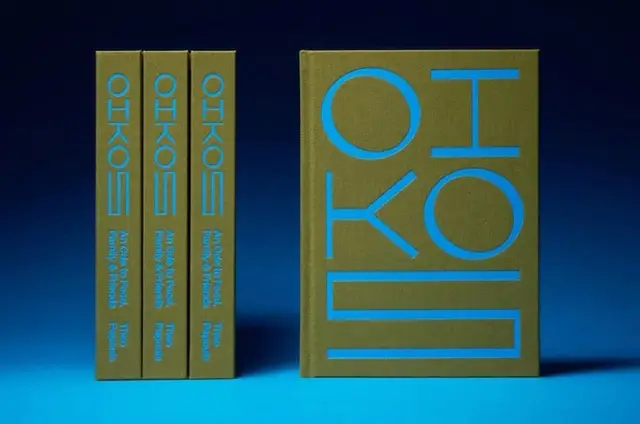Olive-green hardcover book set with cyan geometric typography