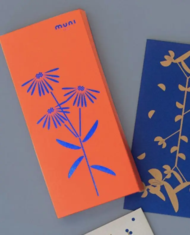 Orange paperboard box with blue foil daisy illustration
