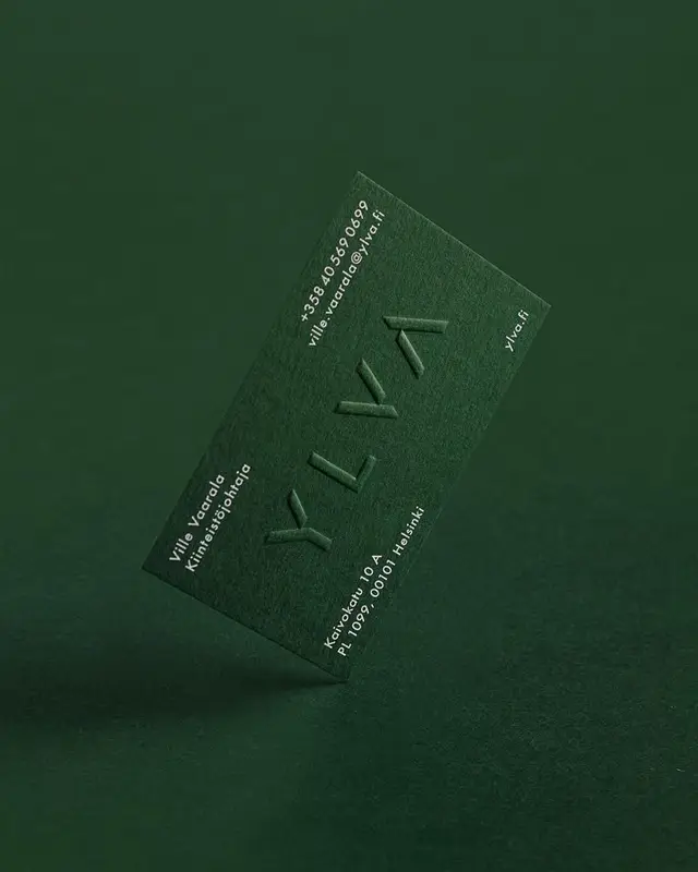 Dark forest-green blind-embossed business card with 'YLVA' logotype