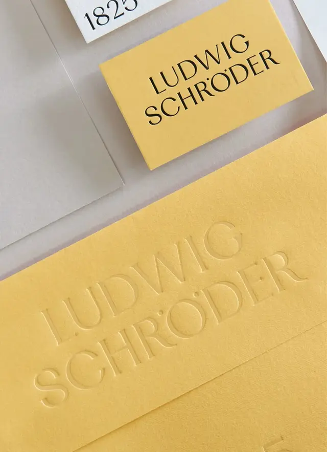 Mustard-yellow stationery with blind debossed 'LUDWIG SCHRÖDER' identity