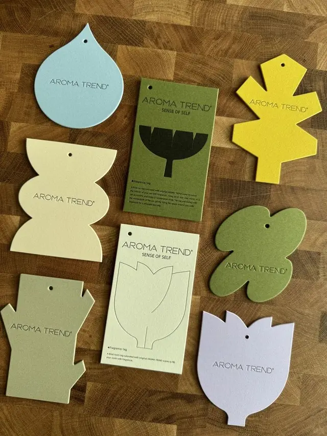 Aroma Trend die-cut fragrance hang tags on butcher-block board