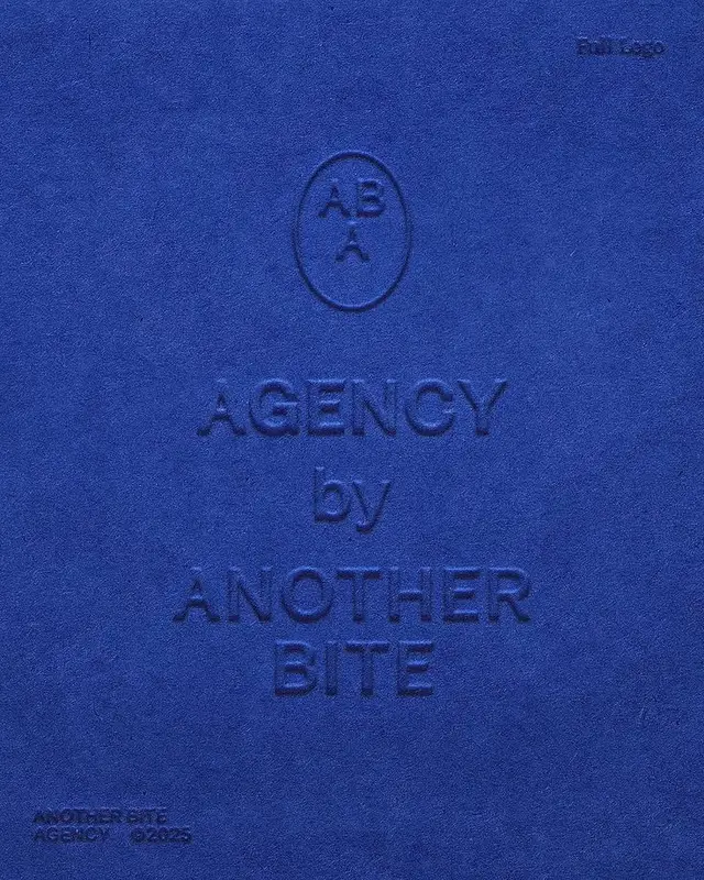Blind‑embossed cobalt blue cover — "AGENCY by ANOTHER BITE"