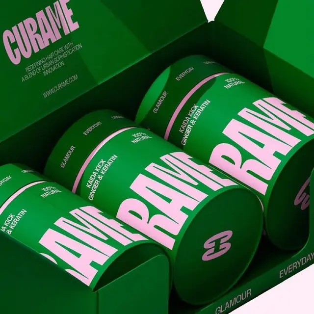 Green packaging with bold pink CURAME cylindrical haircare tins