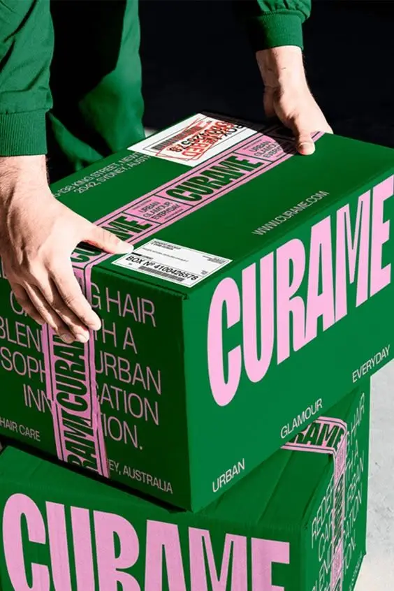 CURAME green shipping boxes with pink logo and branded tape