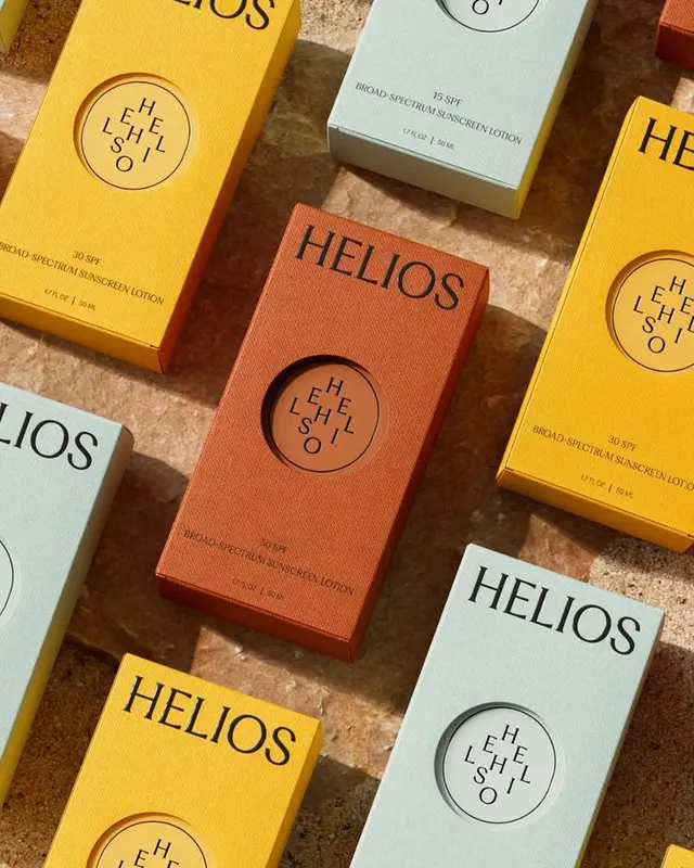 HELIOS sunscreen packaging — yellow, terracotta, pale blue boxes (flat‑lay)