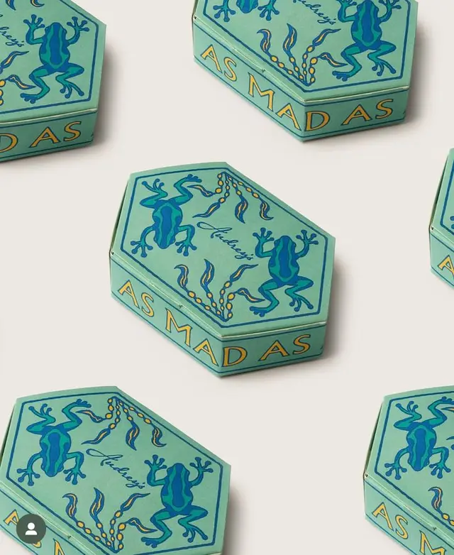 Hexagonal mint-green packaging box with blue frog illustration — "AS MADAS"