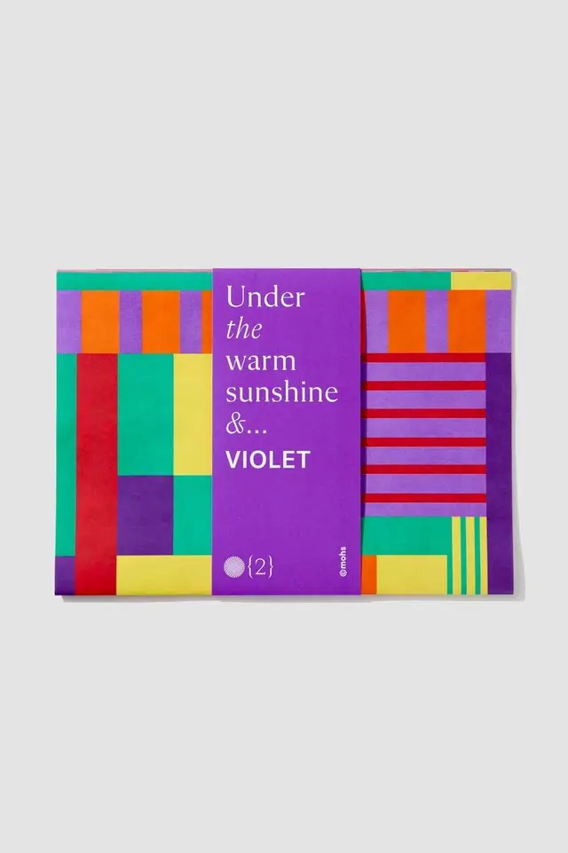 Color-blocked paperboard box with purple sleeve reading 'Under the warm sunshine &... VIO-