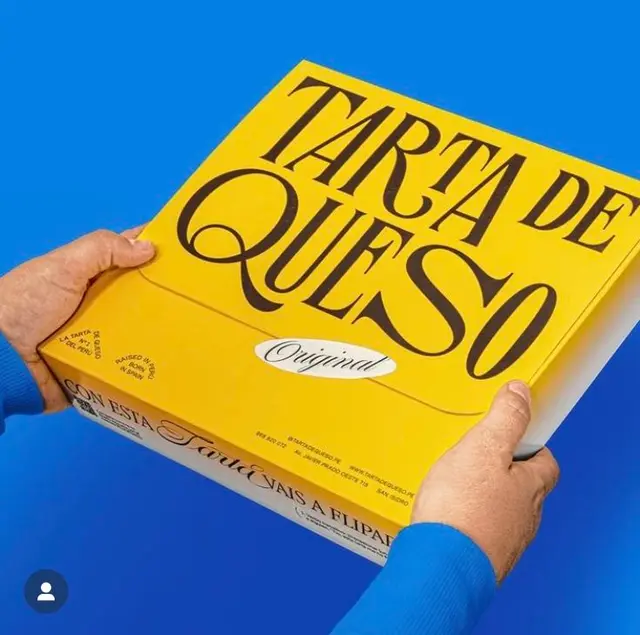 Yellow 'Tarta de Queso' cheesecake box on blue background