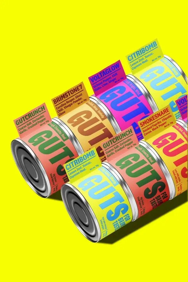 GUTS seasoning cans — colorful packaging mockup on neon yellow
