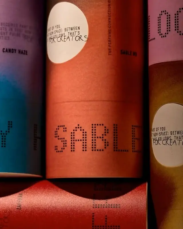 Colorful dot‑matrix 'SABLE' cardboard packaging tubes, close-up