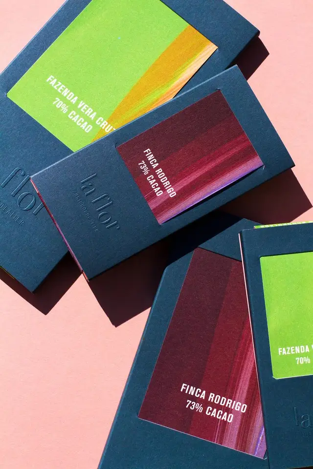 La Flor chocolate bars — navy textured sleeves with bright gradient origin labels