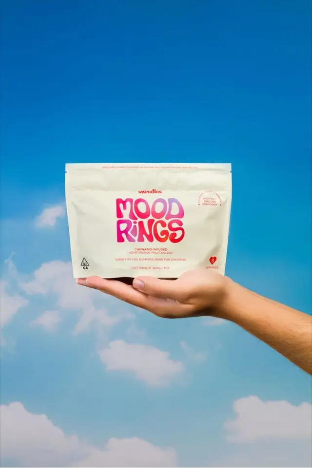 Mood Rings cannabis-infused gummy pouch held against blue sky