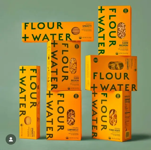 FLOUR + WATER pasta packaging — bold mustard boxes with green typography
