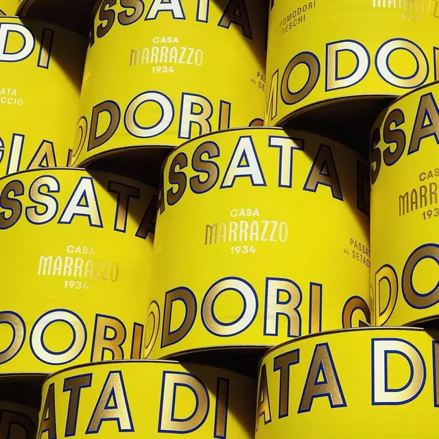 Stacked yellow Casa Marrazzo passata cans — bold blue typography