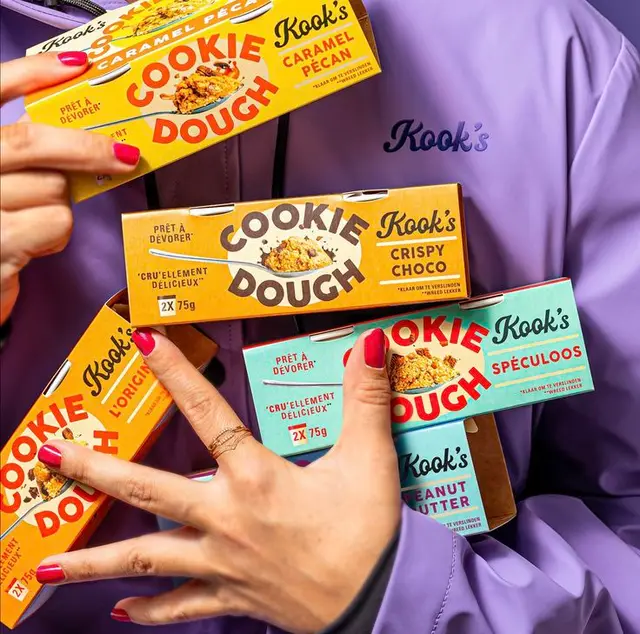 Kook's Cookie Dough assorted flavor boxes held against purple jacket