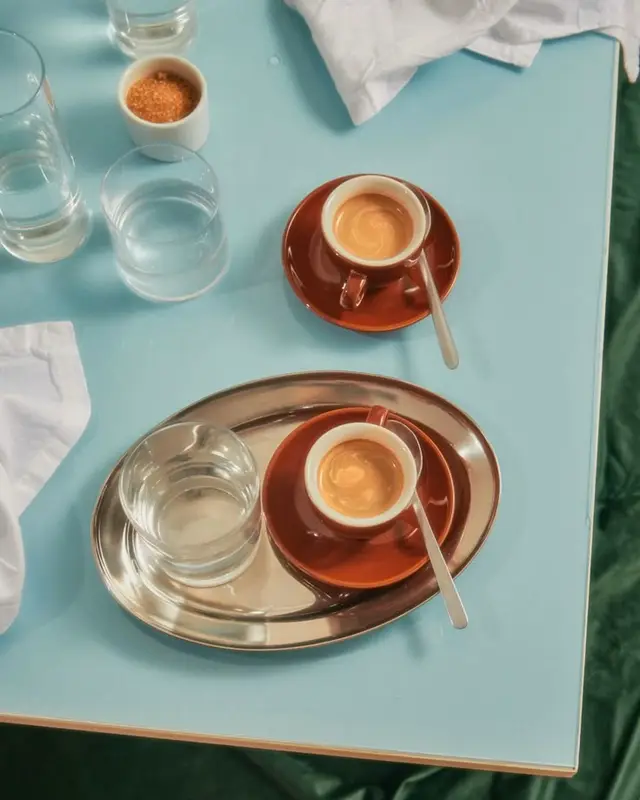 Espresso service on pale blue cafe table