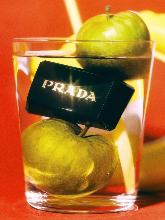 PRADA black box floating in glass with green apples — still life product shot