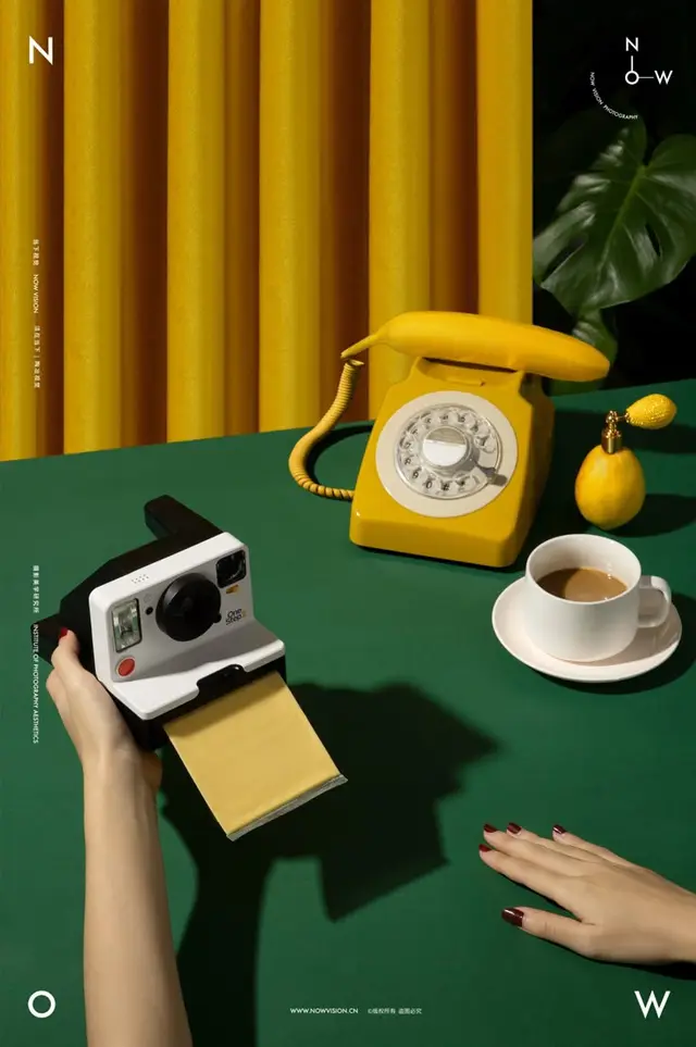 Retro still life: yellow rotary phone and instant film camera on green table