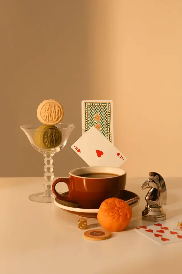Still life with mooncakes, coffee cup and ace of hearts