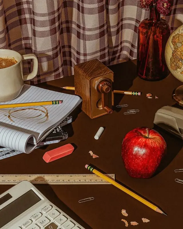 Vintage study desk still life with wooden pencil sharpener and red apple