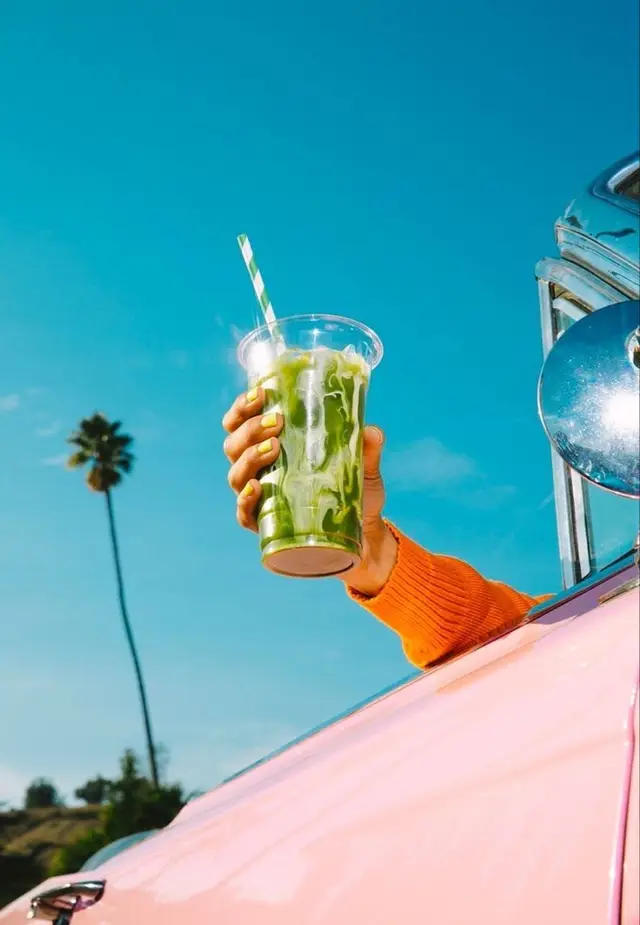 Iced Matcha Latte Out of Pink Convertible Window — Palm Tree, Blue Sky