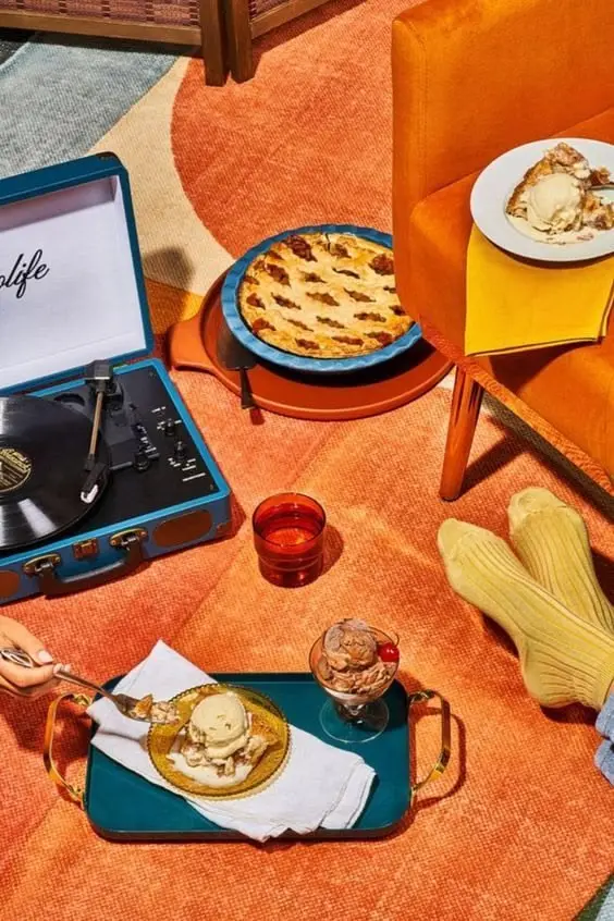 Retro dessert scene with teal suitcase record player, lattice pie and ice cream