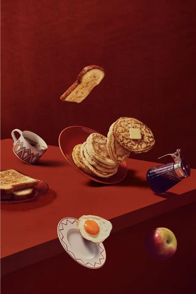 Floating breakfast still life — pancakes, toast, egg and coffee