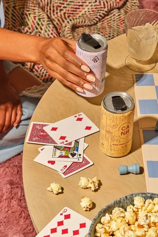 Game-night table with canned Blood Orange drink, playing cards and popcorn