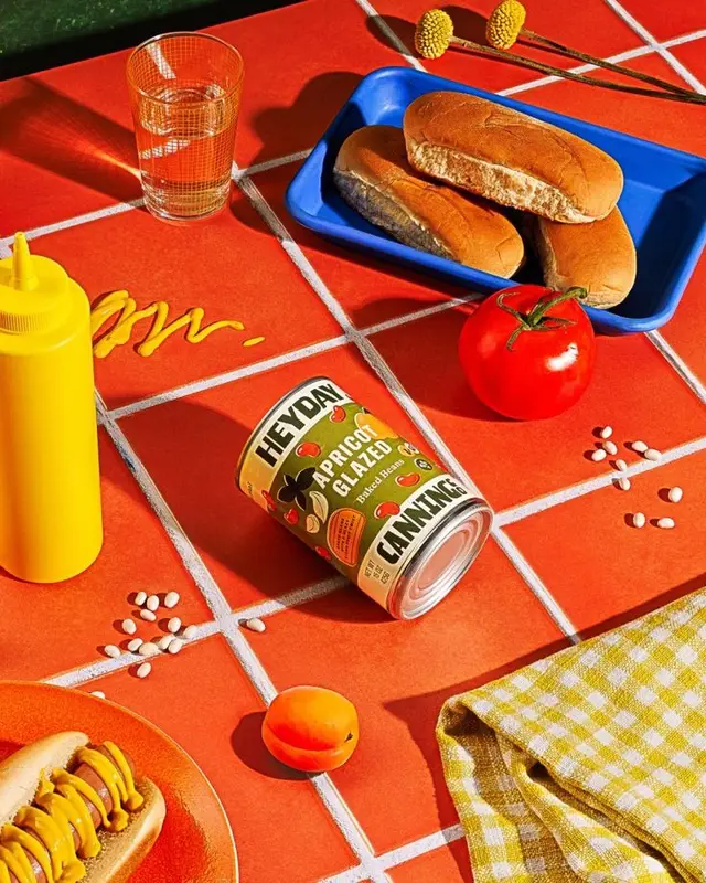HEYDAY 'Apricot Glazed' can on red tiled tabletop with hot dog and blue tray