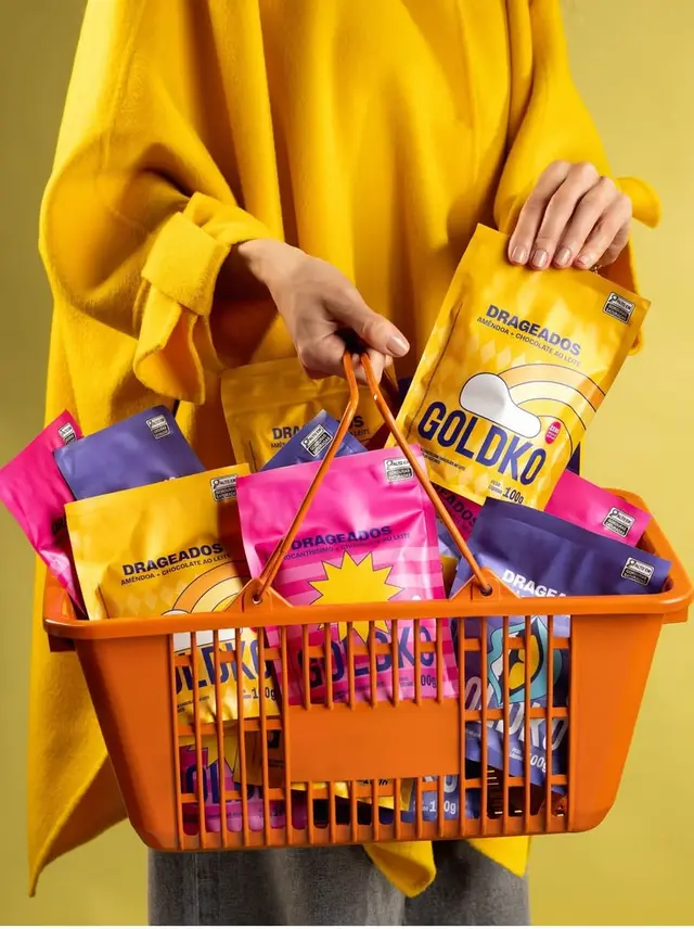 Goldko snack pouches in orange shopping basket — bold yellow product shoot