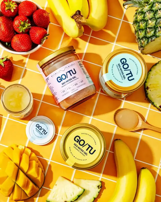 GO/TU Sea Moss Gel jars with tropical fruit flat-lay on yellow tile
