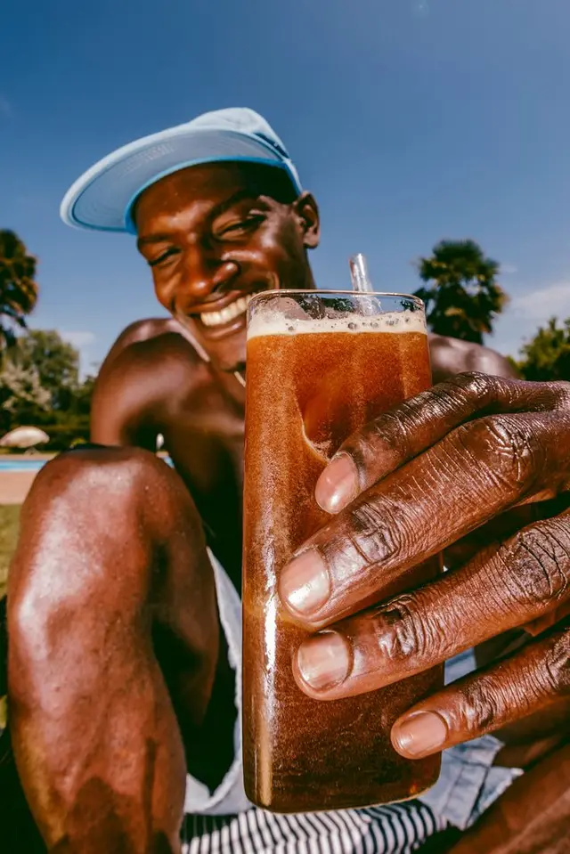 Poolside Refreshment — Smiling Man with Tall Glass and Metal Straw