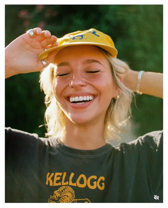 Sunlit candid portrait — yellow cap and Kellogg graphic tee