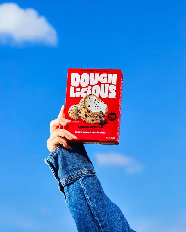 DOUGH LICIOUS chocolate chip cookie dough & gelato bites box held against blue sky