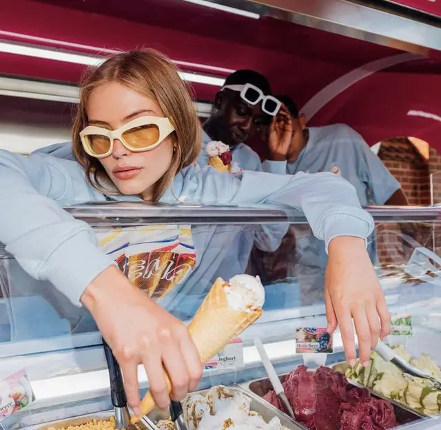 Woman in white sunglasses grabs gelato cone at pink ice cream truck