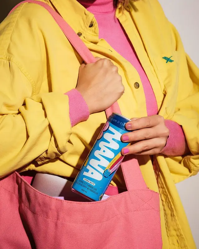 Blue canned drink in pink tote with yellow jacket — color-block fashion close-up