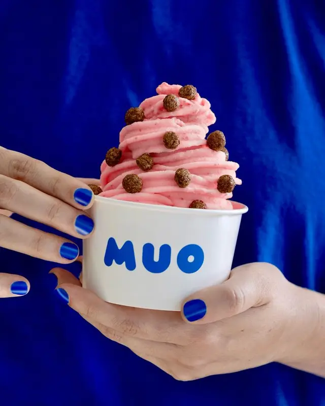 Pink soft-serve in MUO paper cup on cobalt blue background