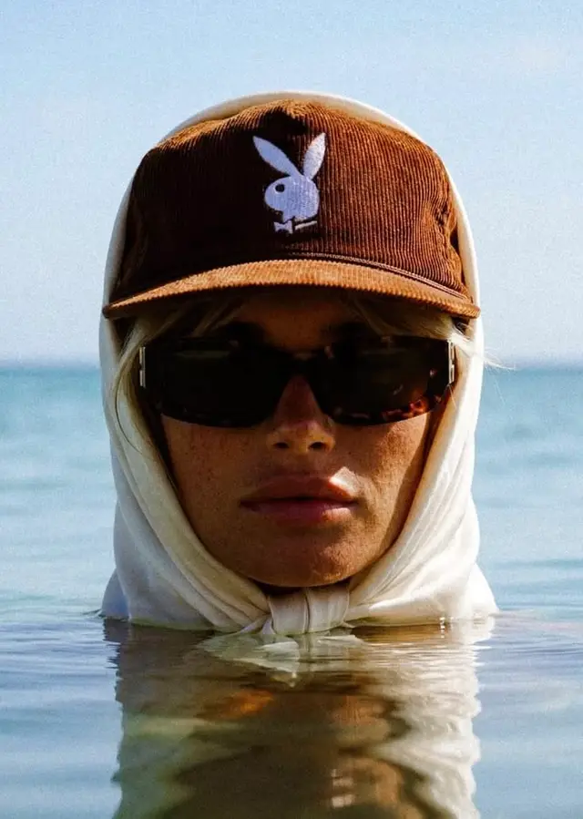 Close-up portrait with Playboy bunny cap partially submerged in sea