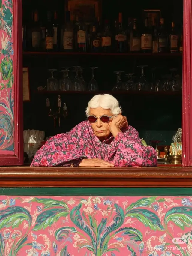 Elderly woman in pink floral jacket at painted bar window