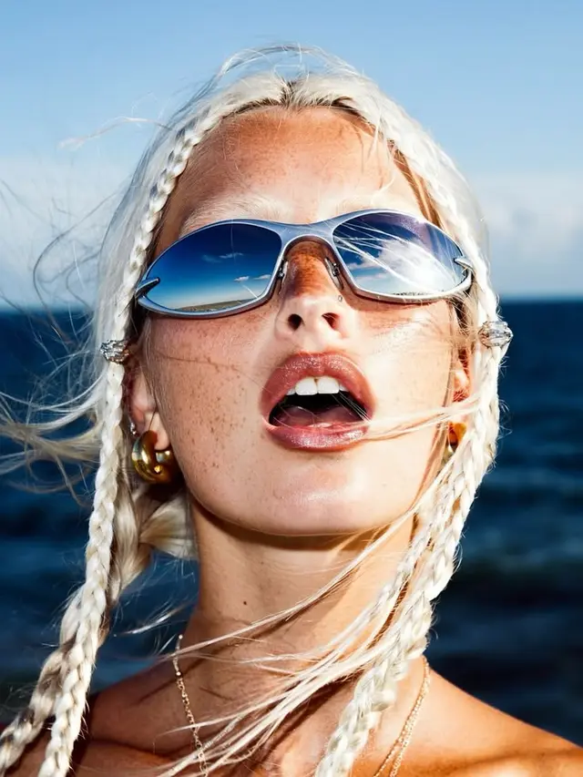 Close-up portrait with mirrored aviator sunglasses reflecting ocean